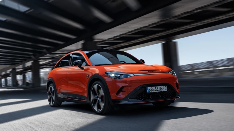 Auto eléctrico smart #3 color naranja siendo conducido por túnel de ciudad.